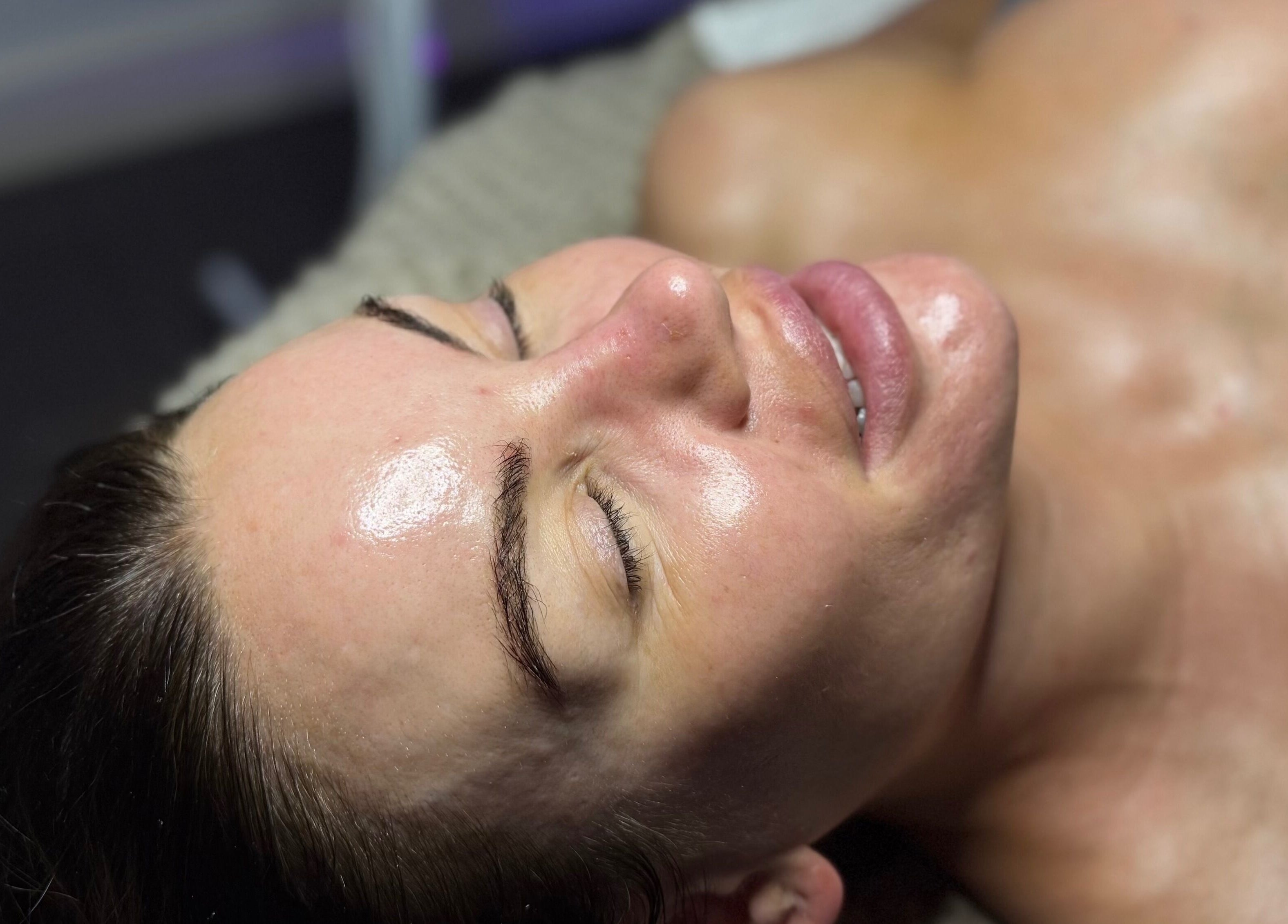 Woman enjoying a facial treatment at The Lash Room in Ayr, Scotland, GB. Her skin looks relaxed and glowing.