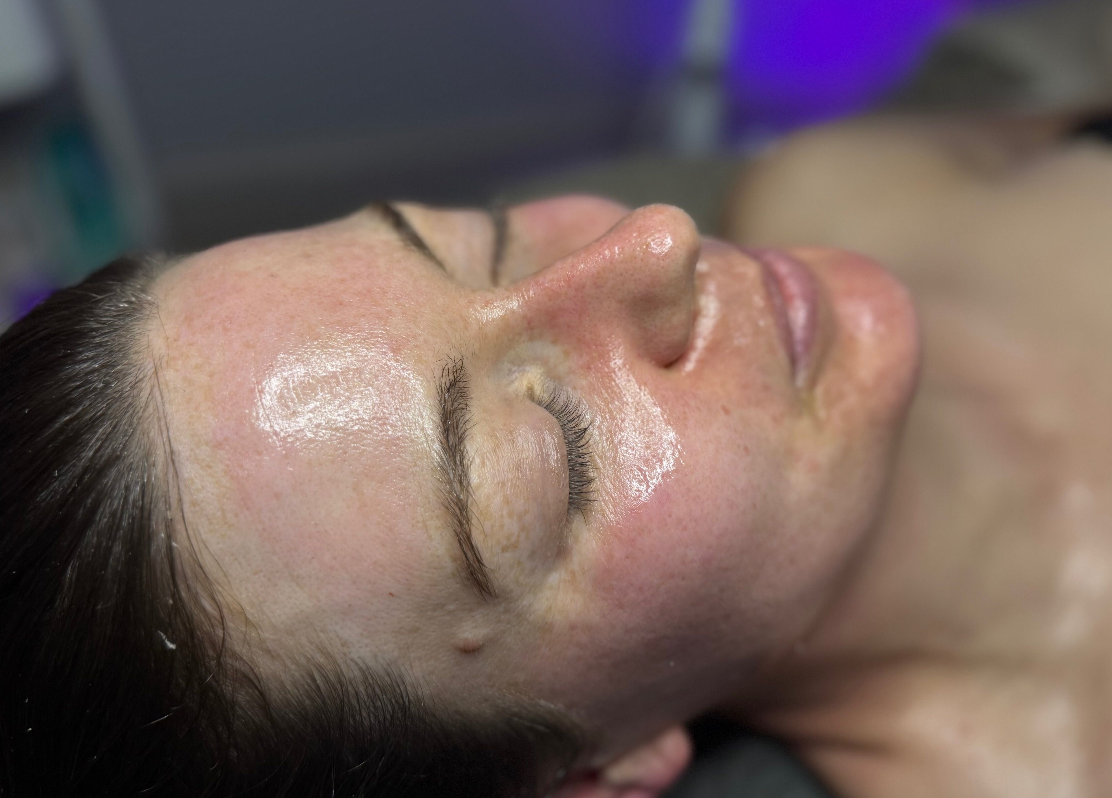 Relaxed woman with radiant skin at The Lash Room, Ayr, Scotland, GB enjoying a rejuvenating facial treatment.