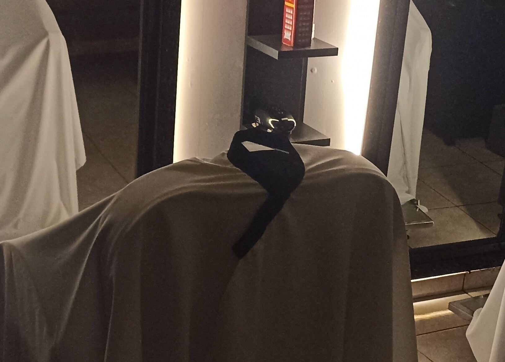 Espaço elegante em WHS Barbearia, São Paulo, com capa de cadeira e iluminação suave.