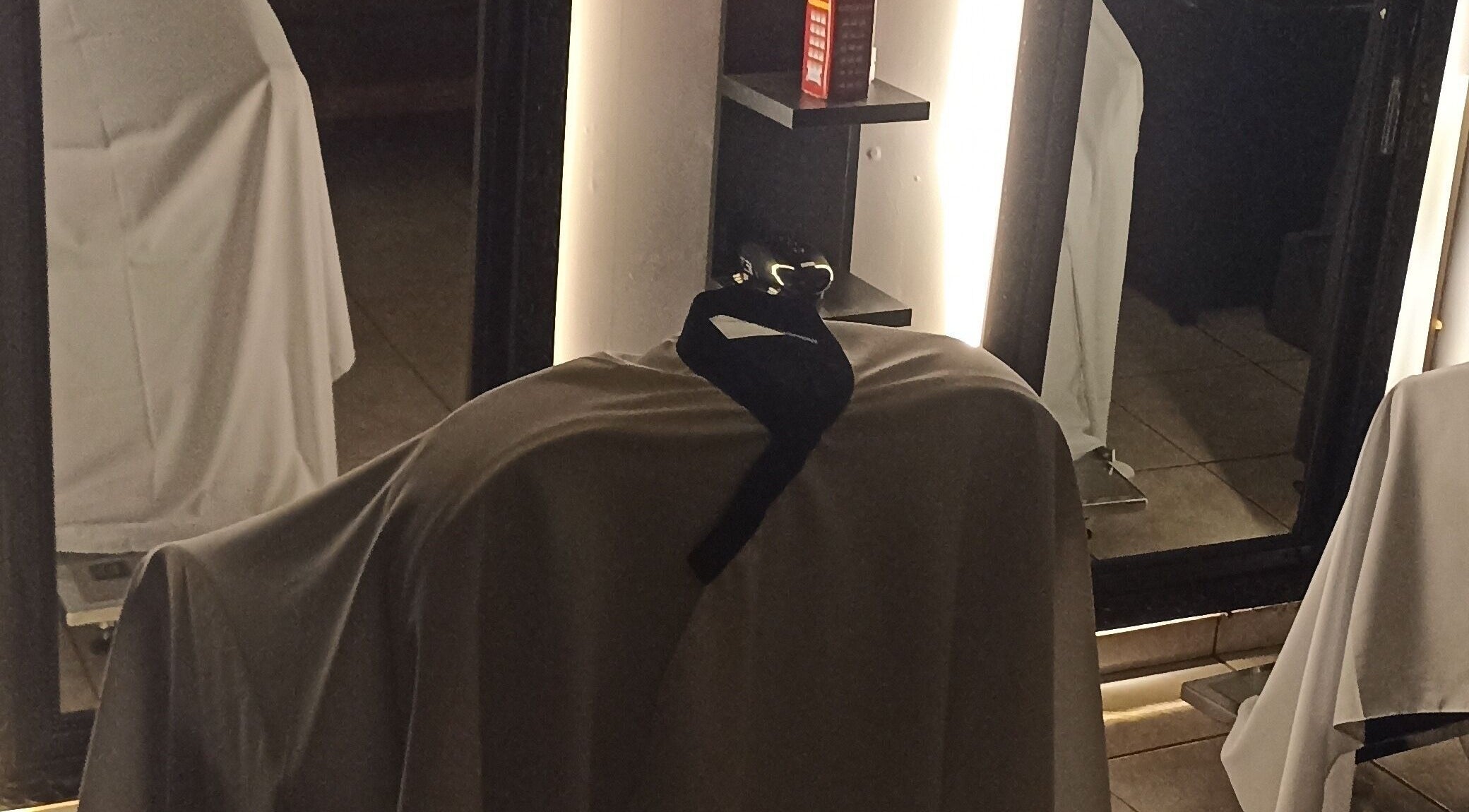 Espaço elegante em WHS Barbearia, São Paulo, com capa de cadeira e iluminação suave.