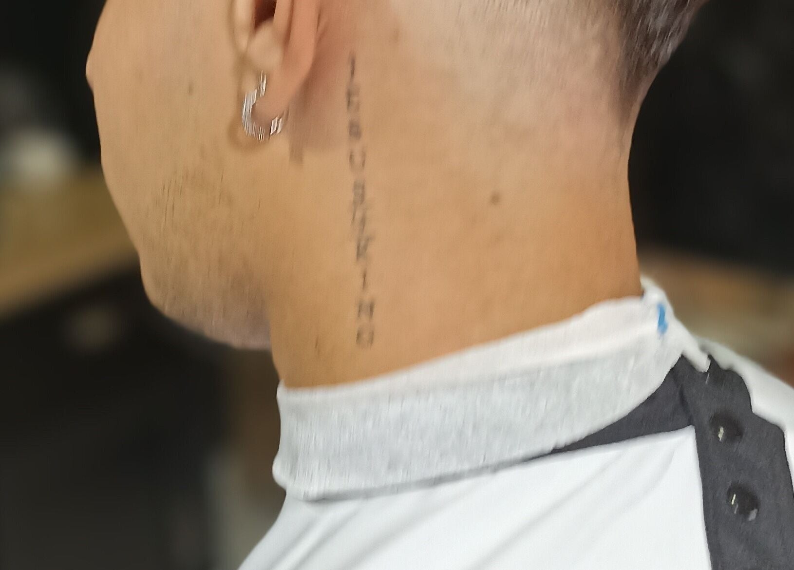 Cliente com corte de cabelo na WHS Barbearia, São Paulo, São Paulo, BR, exibindo tatuagem discreta.