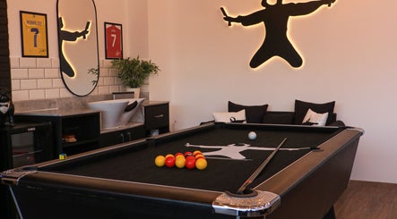 Stylish interior of Sweeney Todds Barbers with pool table in Arjan, Dubai, AE offering a leisure-filled ambiance.