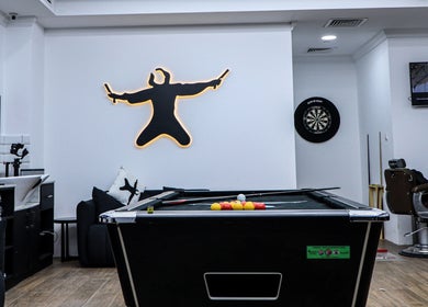 Sweeney Todds Barbers in Arjan, Dubai features a stylish lounge with pool table and dartboard for client relaxation.