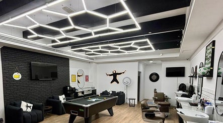 Modern interior of Sweeney Todds Barbers at Arjan, Dubai, AE, featuring stylish lighting and barber chairs.
