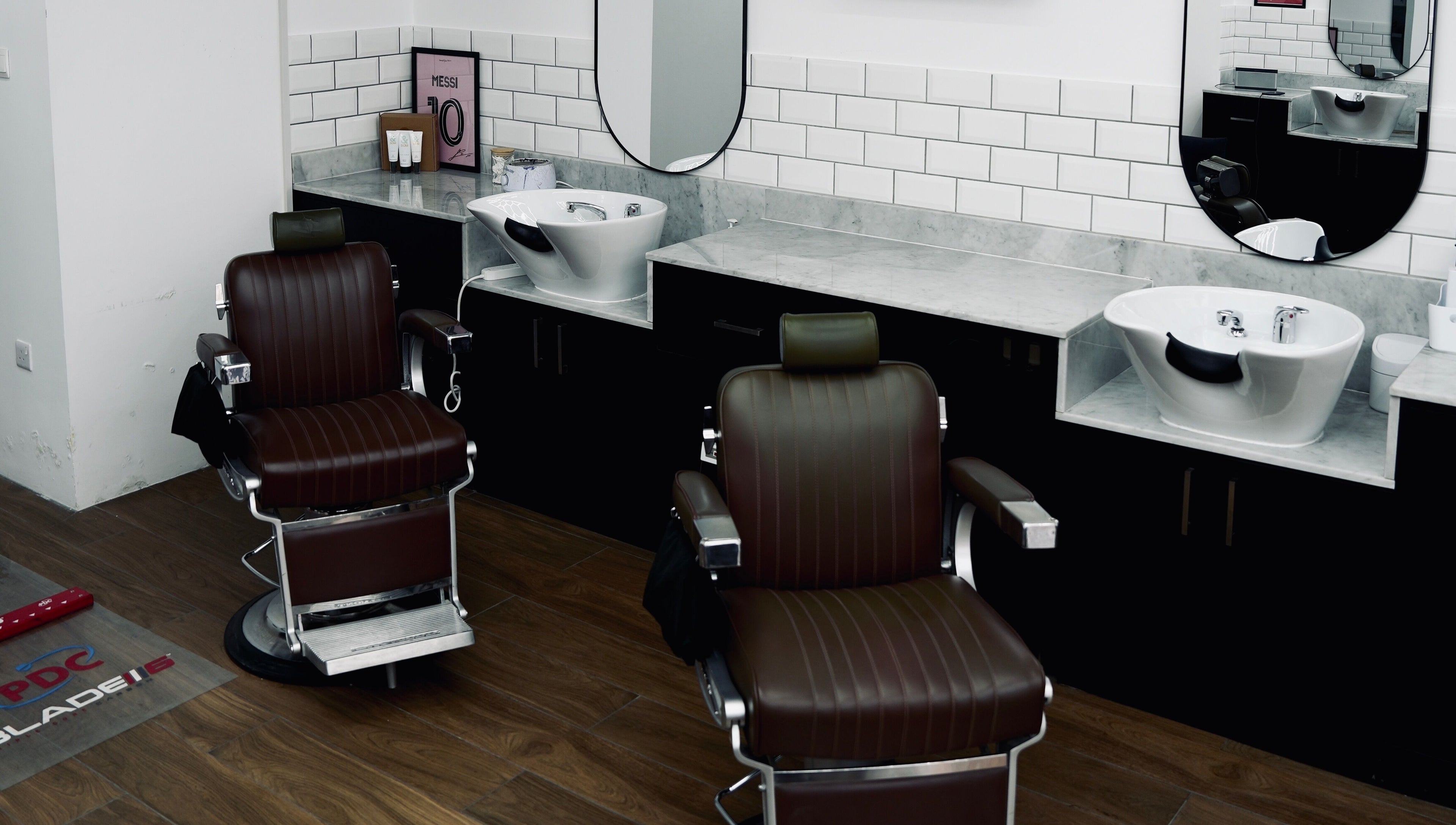 Modern barbershop chairs and washbasins at Plus 44 Barber, Arjan, Dubai, AE, showcasing sleek design.