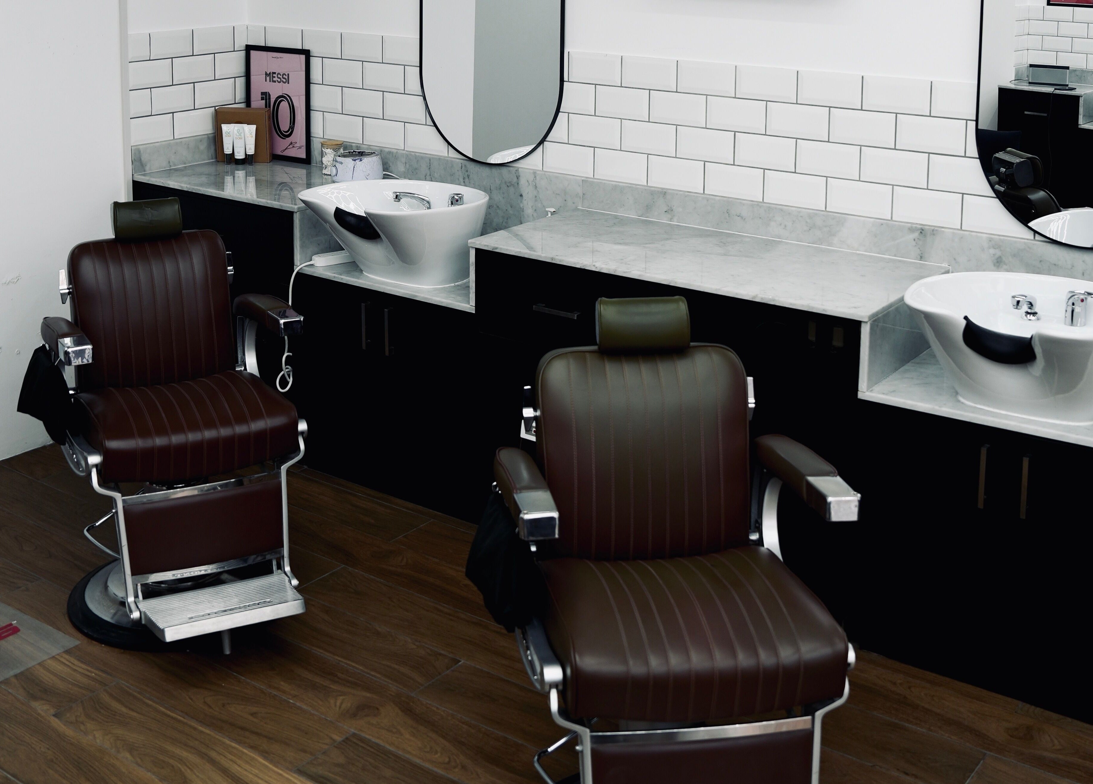 Modern barbershop chairs and washbasins at Plus 44 Barber, Arjan, Dubai, AE, showcasing sleek design.