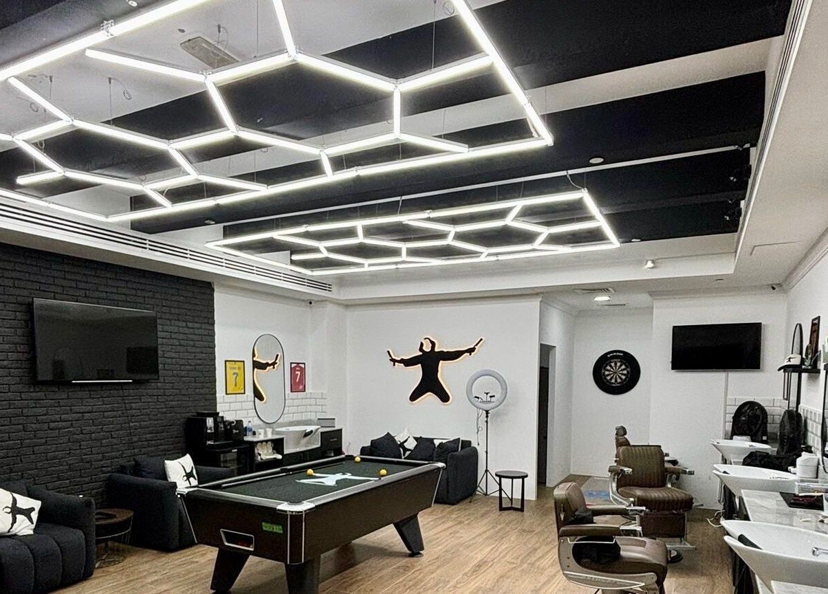 Chic interior of Plus 44 Barber featuring modern lighting and stylish decor in Arjan, Dubai, AE.