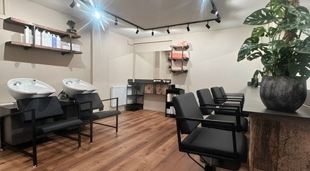 Modern hair salon at Render, Birmingham, England, GB with sleek chairs and washing stations.