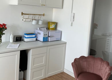 Elegant workspace at PAŁKA | Witney Beauty & Aesthetics in Witney, England, GB featuring a pink chair and flowers.