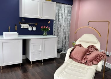 Luxurious beauty treatment room at Jolanta Palka, Witney, England, GB with plush seating and chic decor.