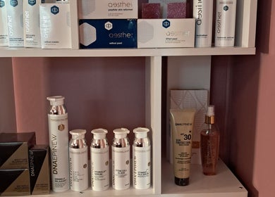 Skincare products at Synergy Skin And Body Studio, Cape Town, Western Cape, ZA displayed on a white shelf.