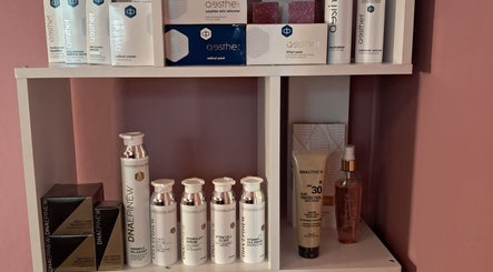 Skincare products at Synergy Skin And Body Studio, Cape Town, Western Cape, ZA displayed on a white shelf.