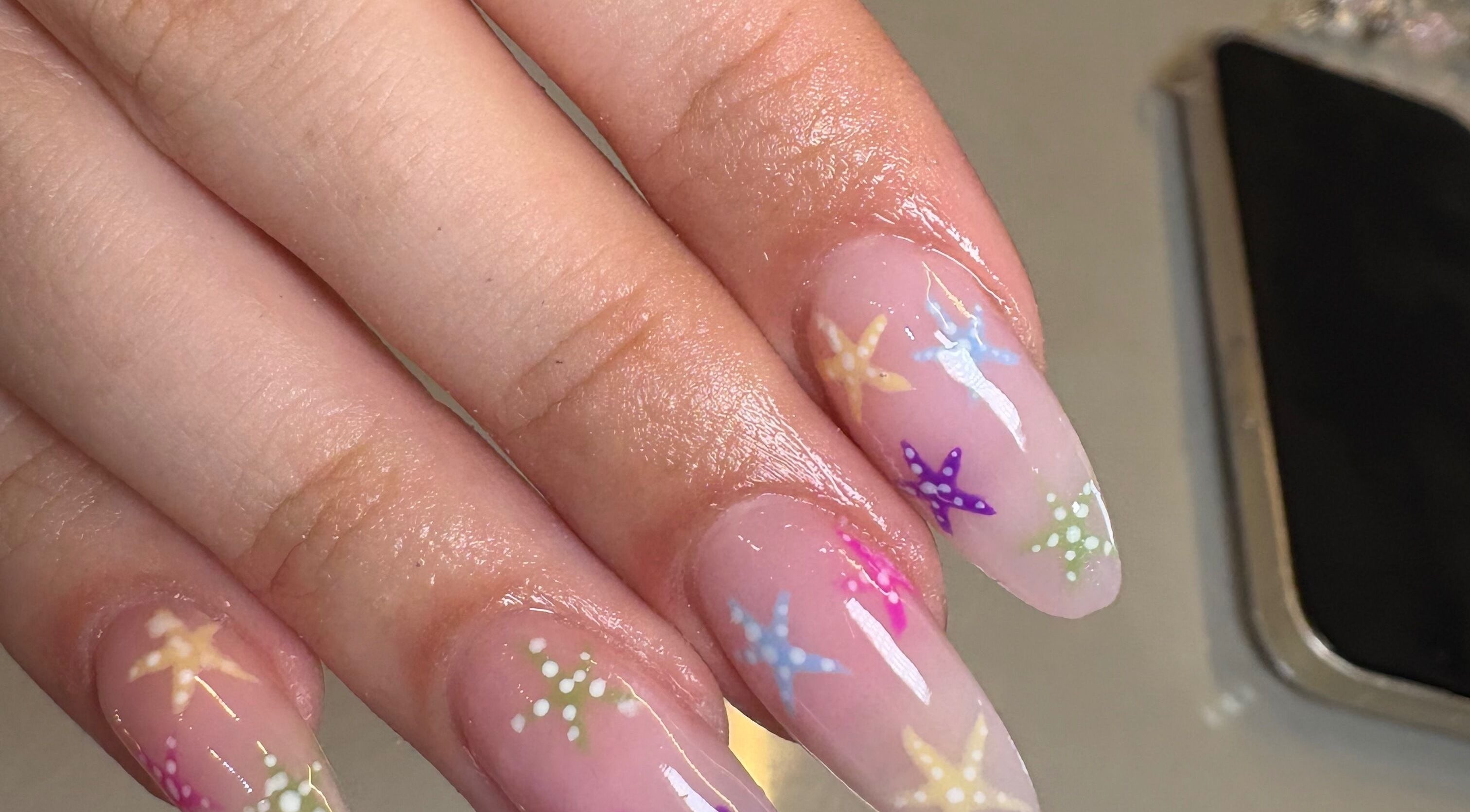 Colorful star-themed nail art by Nails by Emily Katie in Burnley, England, GB for a chic look.