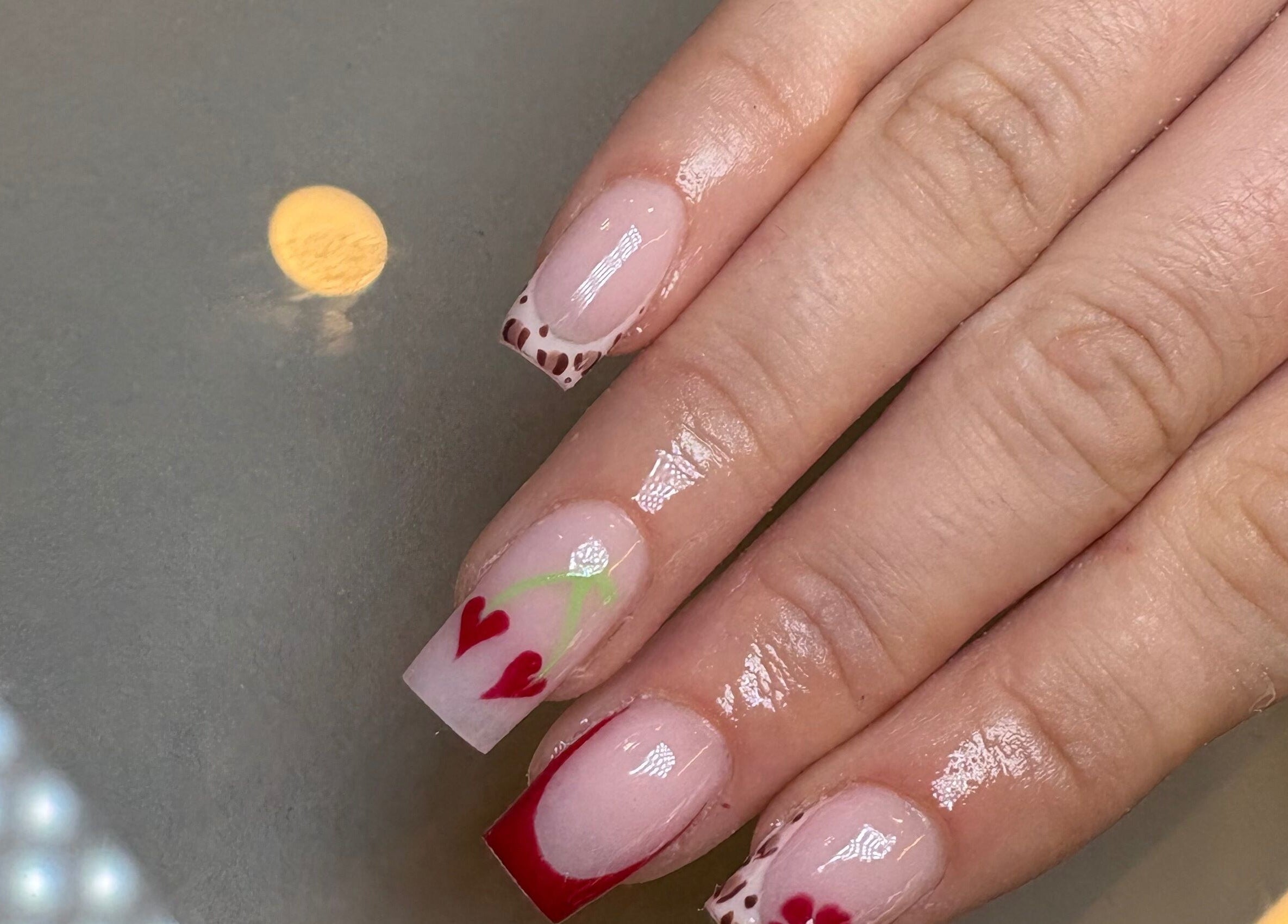 Stylish nail art with heart and leopard designs at Nails by Emily Katie, Burnley, England, GB.