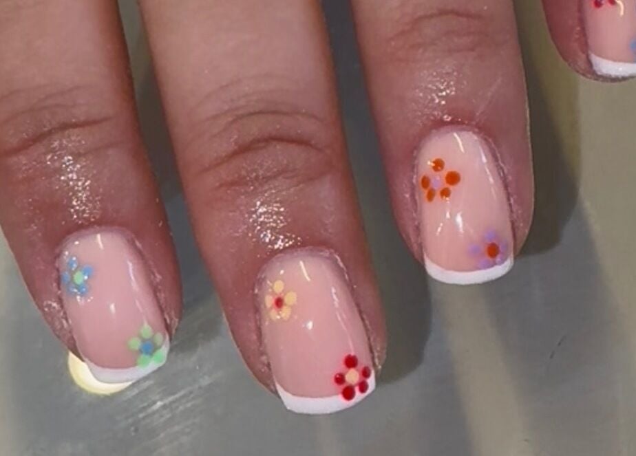Chic floral nail art at Nails by Emily Katie, Burnley, England, GB with vibrant flower designs on French tips.