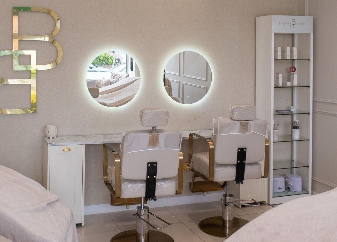 Chic salon interior at Browbabe Welling, England, GB with stylish chairs and mirrors.