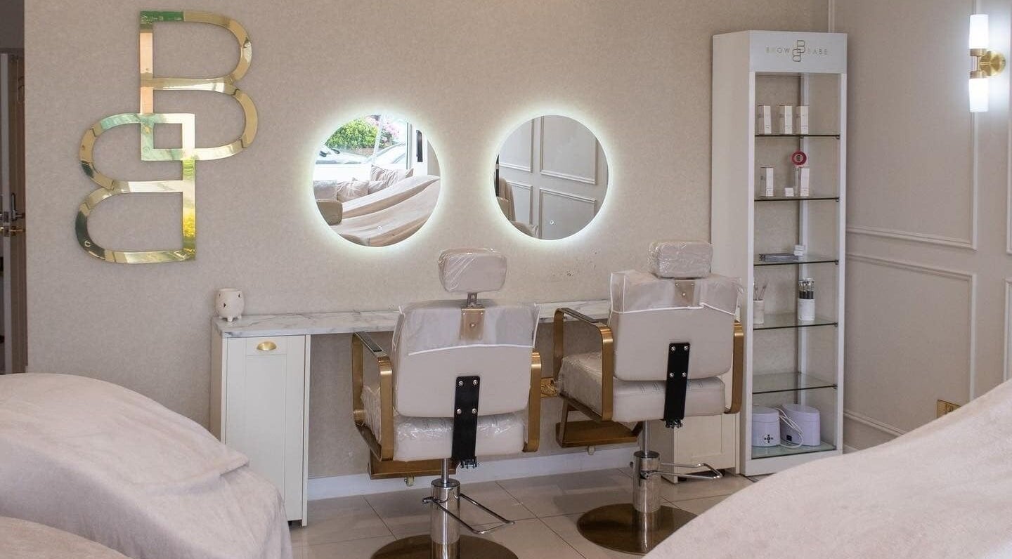 Chic salon interior at Browbabe Welling, England, GB with stylish chairs and mirrors.