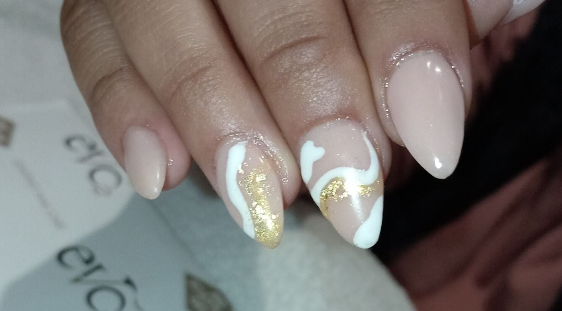Elegant nail art with gold and white swirls at Milla Aesthetics, Randfontein, Gauteng, ZA.