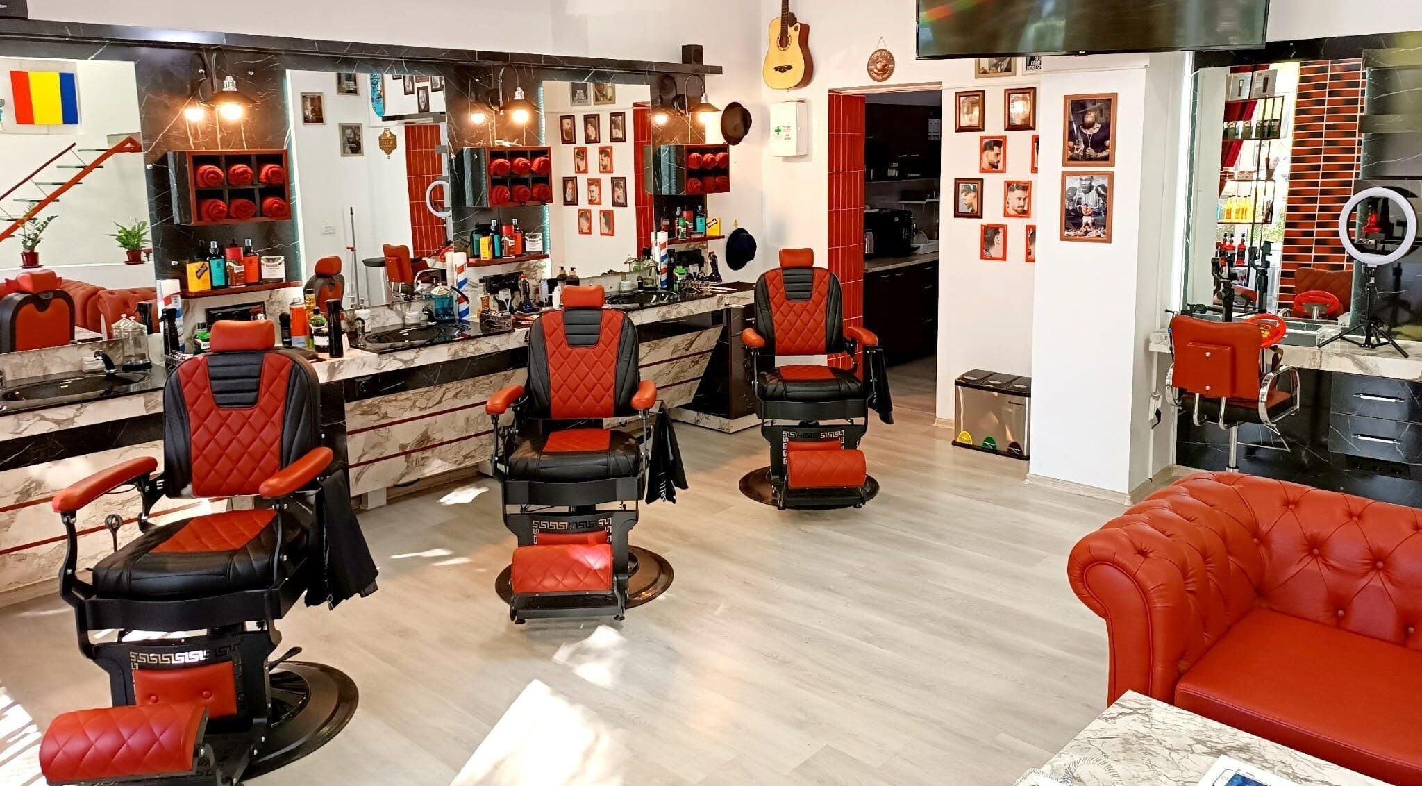 Interior modern la Vienna Style Salon din București cu scaune roșii elegante.