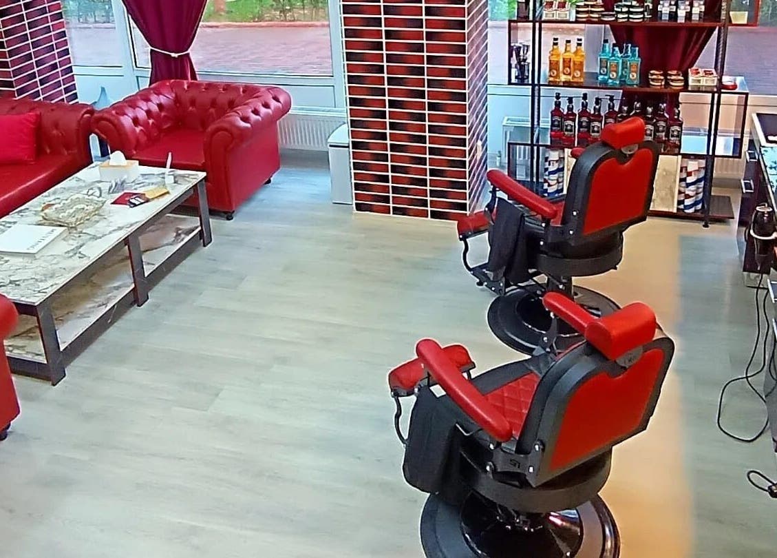 Interior retro elegant la Vienna Style Salon, București, RO, cu scaune roșii și canapele.