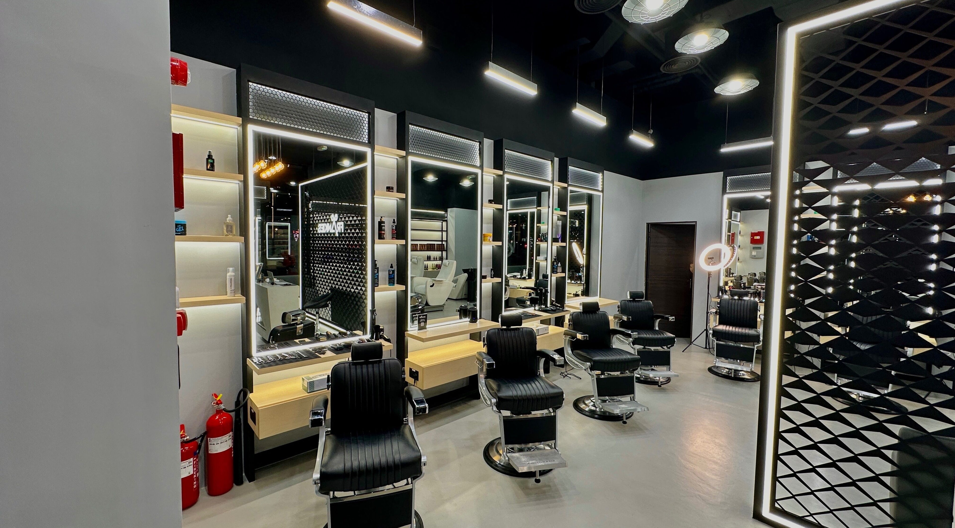 Stylish interior of Frankies Barbershop, Dubai, Dubai, AE with modern barber chairs and mirrors.