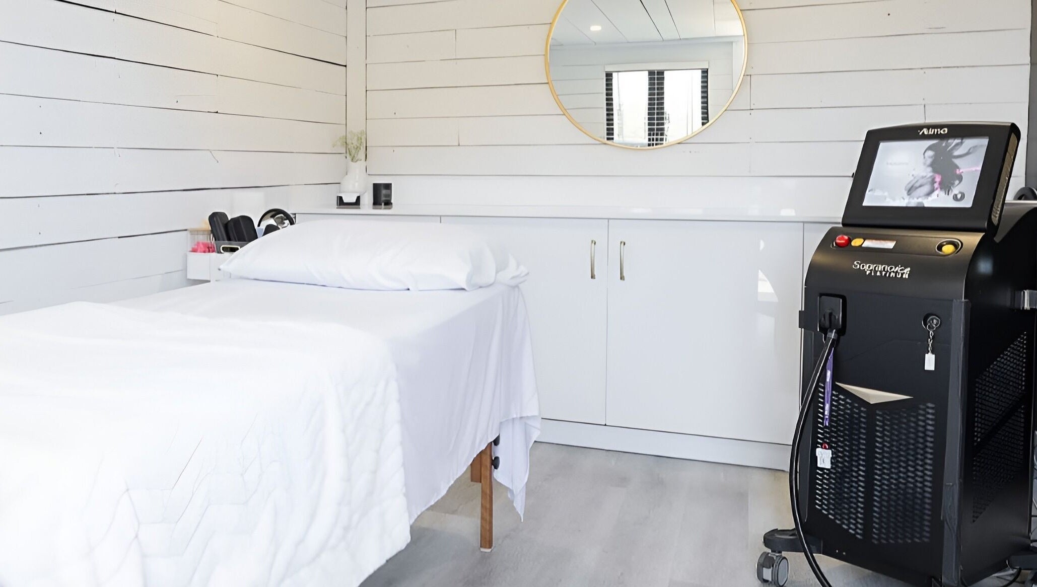 Minimalist spa room at Bare Cabin, Port Colborne, Ontario, CA with massage table and modern equipment.