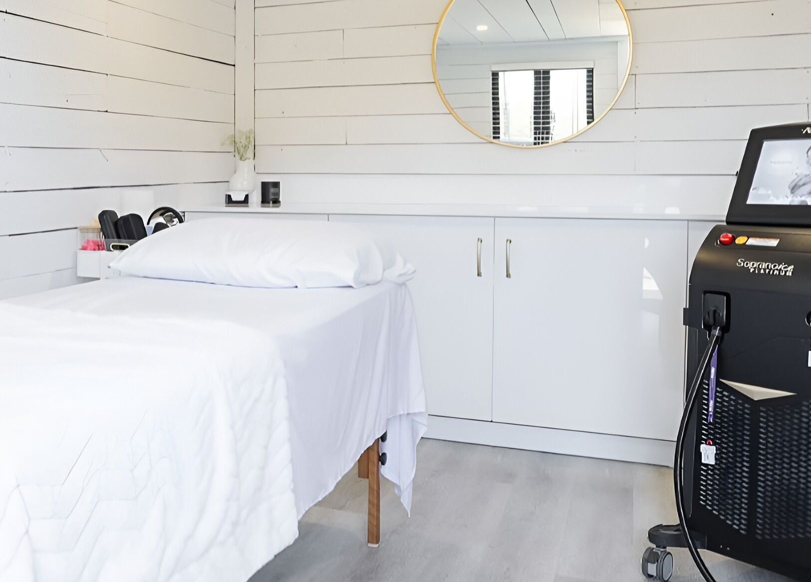 Minimalist spa room at Bare Cabin, Port Colborne, Ontario, CA with massage table and modern equipment.