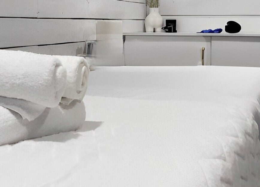 Tranquil massage table setup with fresh towels at Bare Cabin, Port Colborne, Ontario, CA.