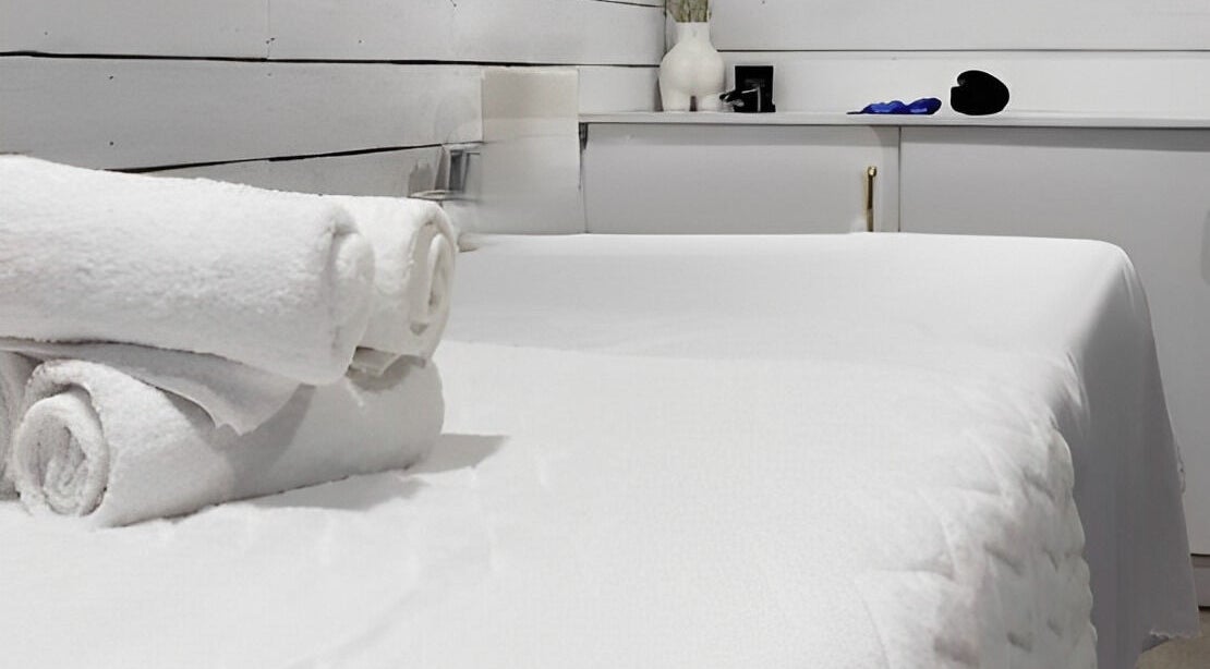 Tranquil massage table setup with fresh towels at Bare Cabin, Port Colborne, Ontario, CA.