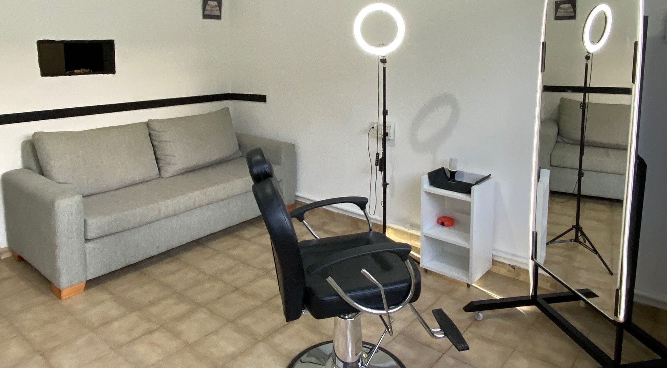 Sala de estética en MZ STUDIO, City Bell, Provincia De Buenos Aires, AR con silla de peluquería y espejo iluminado.