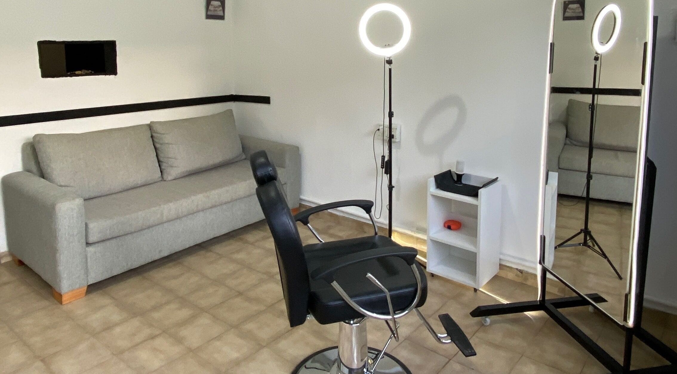 Sala de estética en MZ STUDIO, City Bell, Provincia De Buenos Aires, AR con silla de peluquería y espejo iluminado.