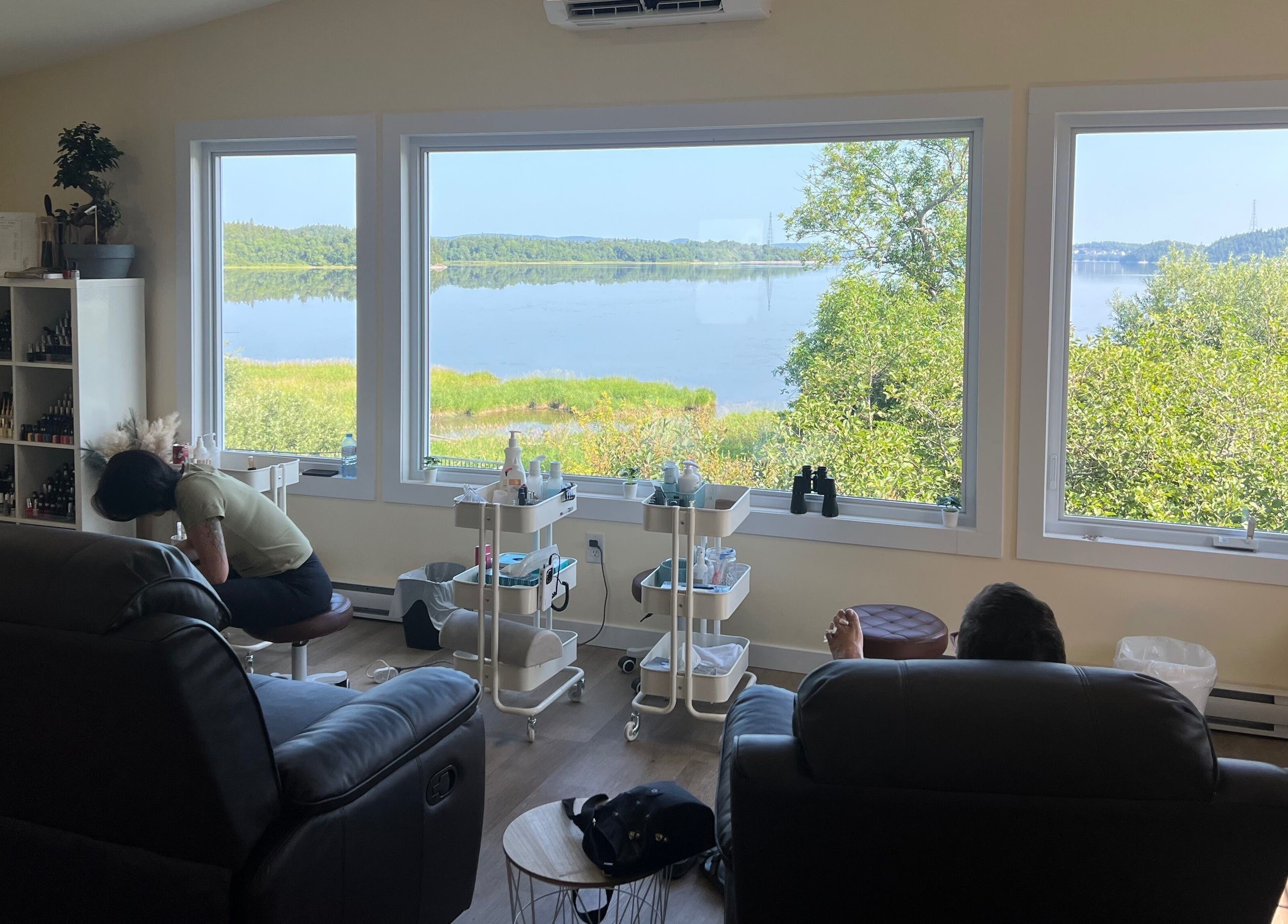 Relaxing room at Water's Edge Aesthetics, Saint John, NB, CA with a serene lake view through large windows.