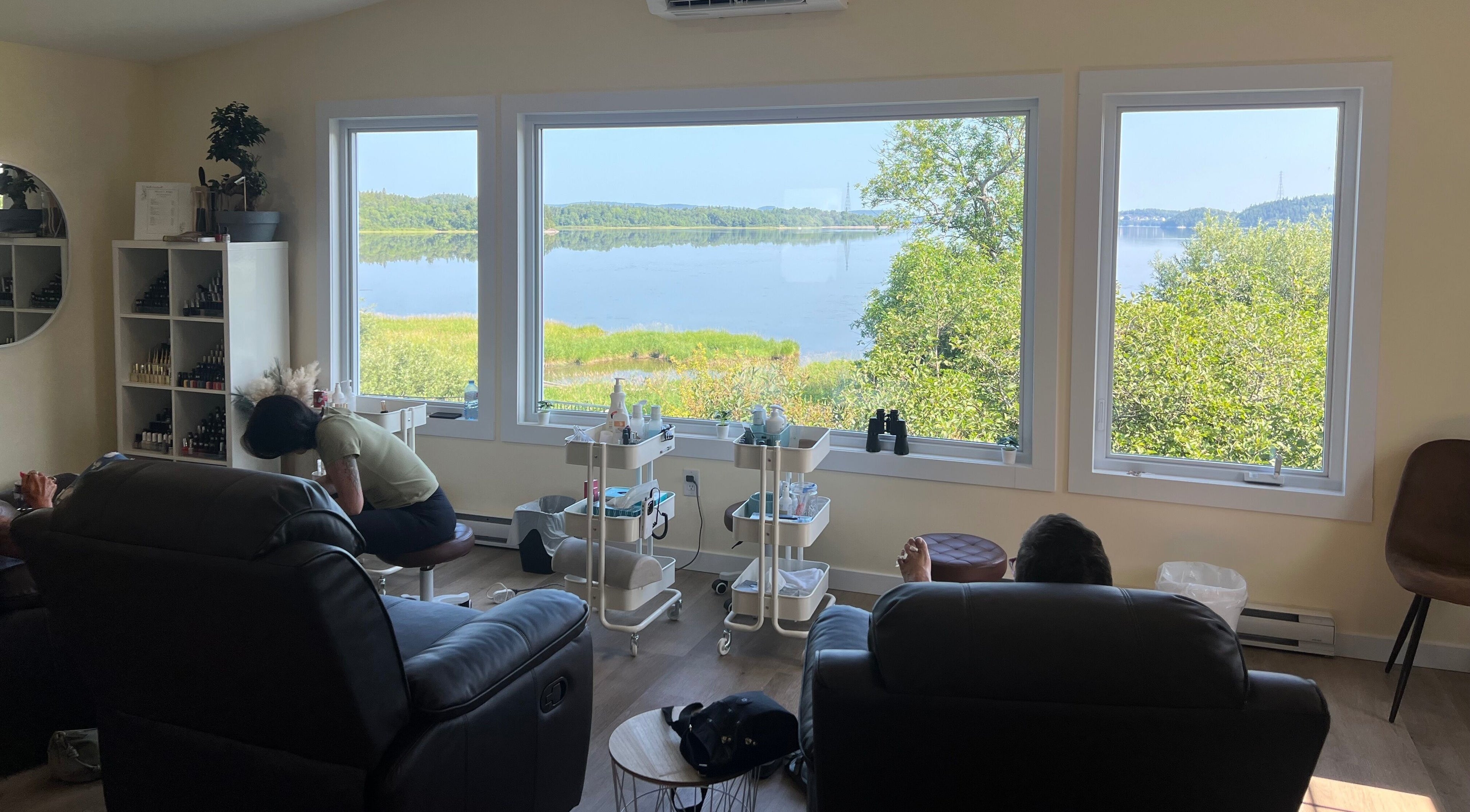 Relaxing room at Water's Edge Aesthetics, Saint John, NB, CA with a serene lake view through large windows.