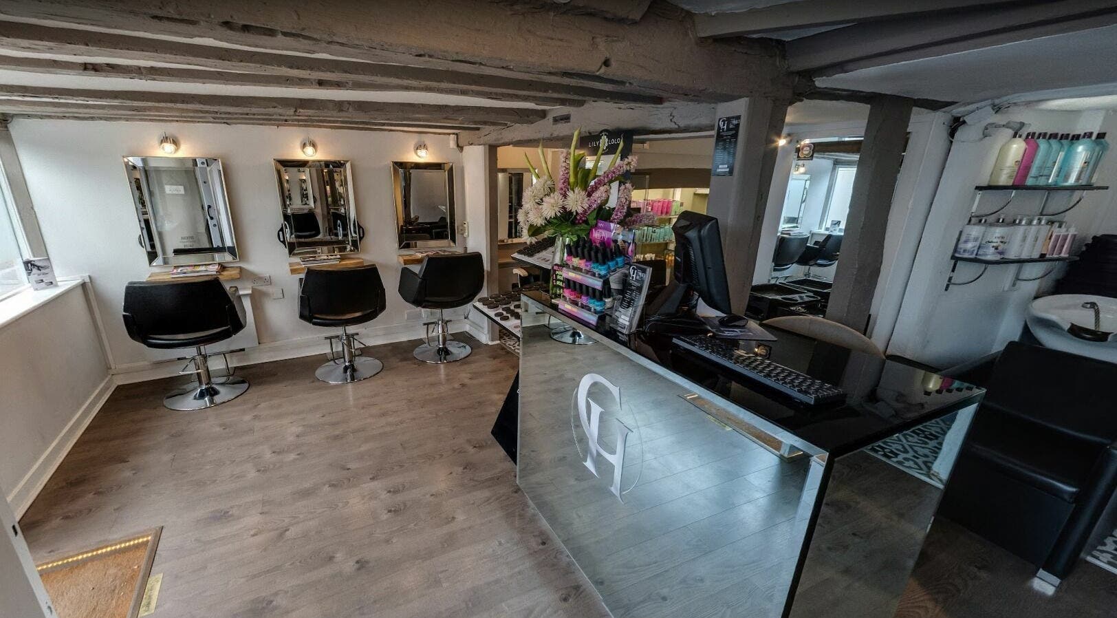 Modern salon interior of Hair By Charlotte Hayes in Amersham, England, GB featuring stylish chairs and mirrors.