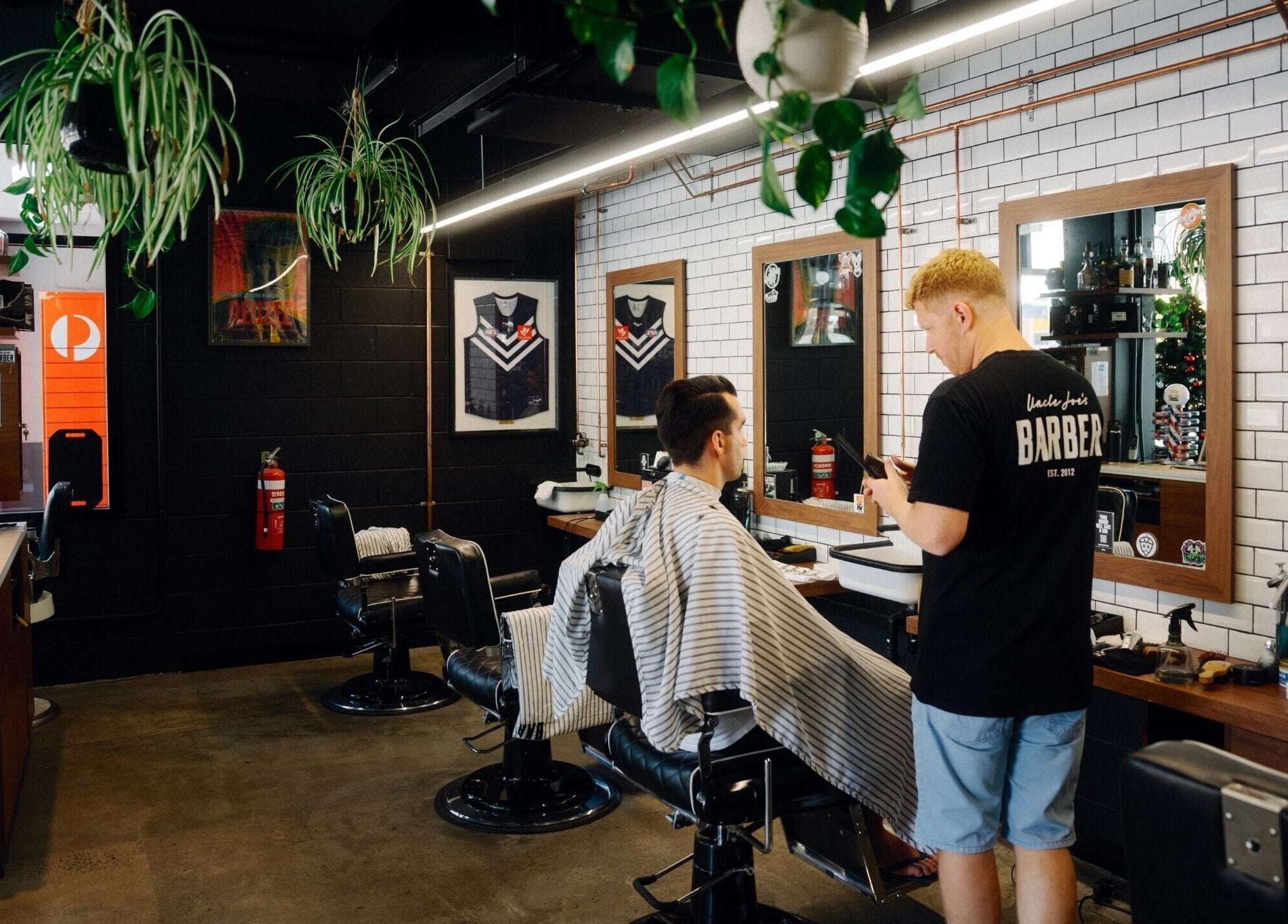 Inside view of Uncle Joes Barber - Fremantle, showcasing modern barber chairs and sleek decor in Fremantle, Western Australia, AU.