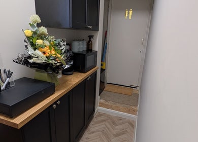 Welcoming hallway at Charli's Beauty Company in Southend-on-sea, England, GB with floral arrangement on a wooden counter.