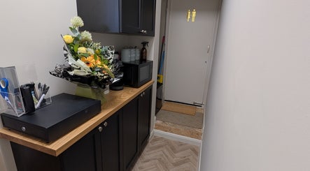 Welcoming hallway at Charli's Beauty Company in Southend-on-sea, England, GB with floral arrangement on a wooden counter.