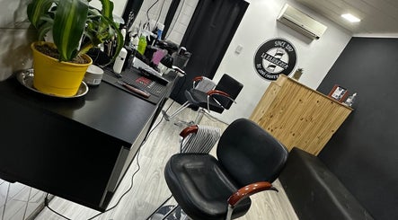 Interior elegante de LA BARBERIA en Tortuguitas, Provincia De Buenos Aires, AR, con sillas de cuero y plantas.