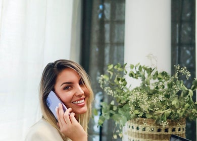 Woman smiling while on a phone call at Con Calma, Elda, Comunidad Valenciana, ES.