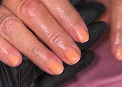 Fresh peach nail polish on hands by Mobile nails by Karli in Stilton, England, GB.