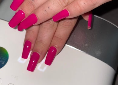 Bright pink nails showcased by Mobile nails by Karli in Stilton, England, GB in front of a UV lamp.