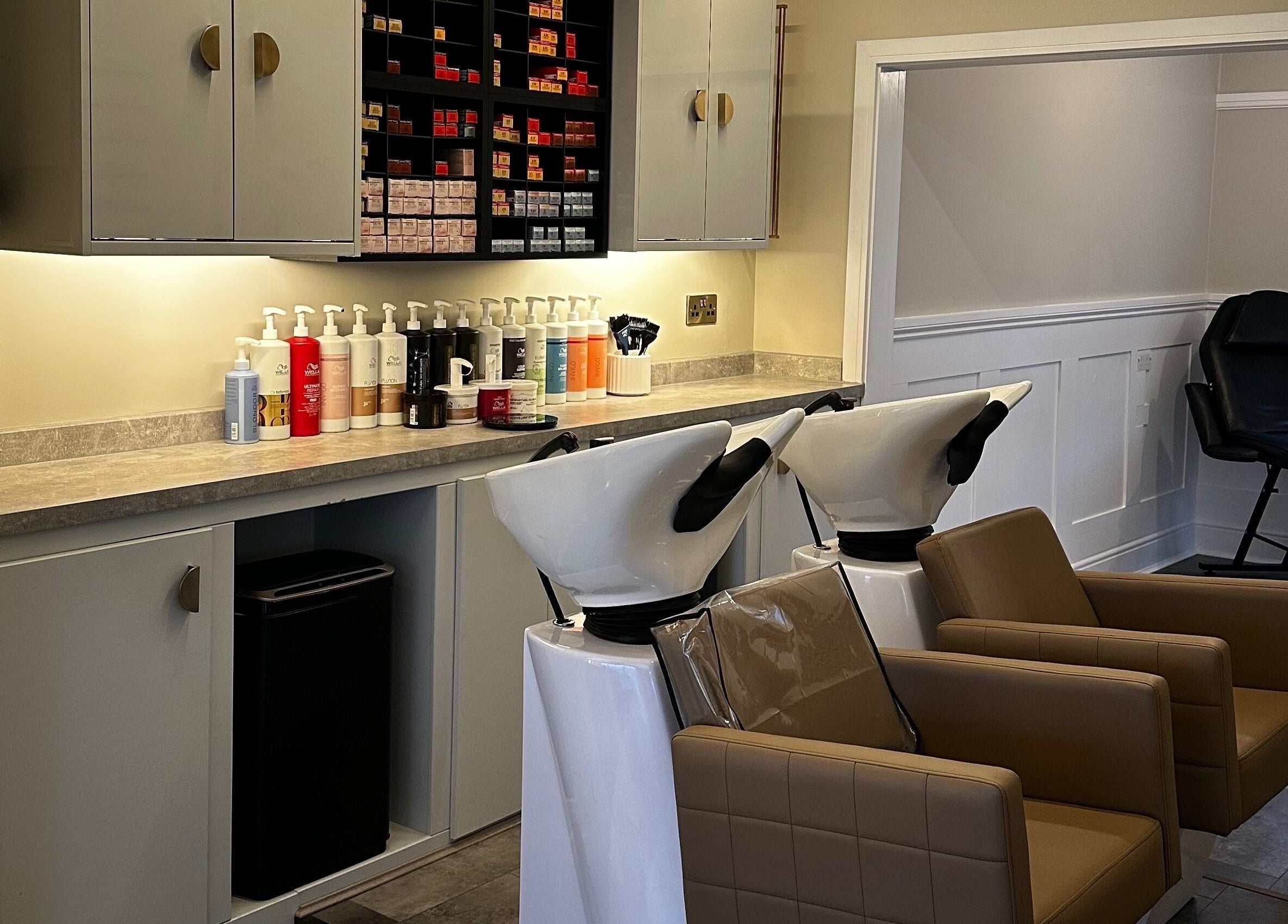Elegant wash station at Halt Salon in Nottingham, GB, featuring brown leather chairs and premium hair products.