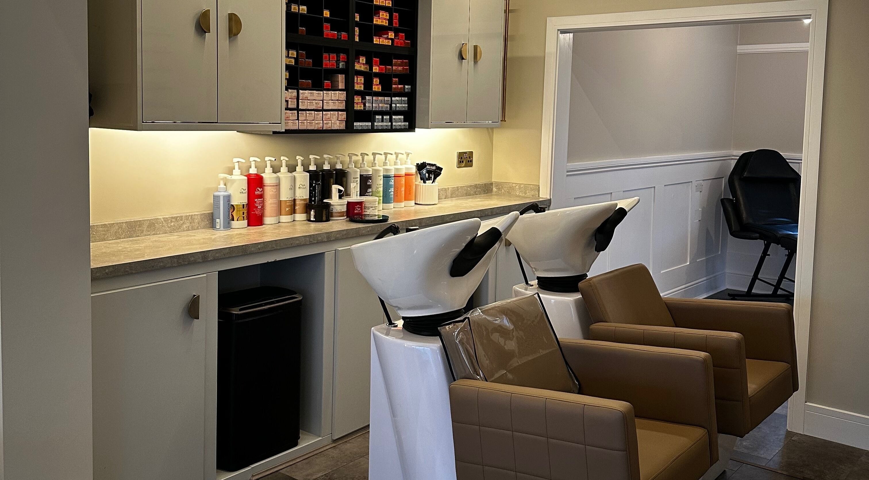 Elegant wash station at Halt Salon in Nottingham, GB, featuring brown leather chairs and premium hair products.
