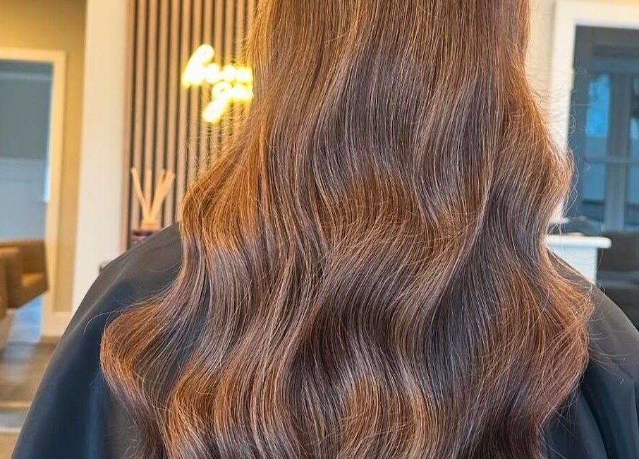 Elegant wavy hairstyle at Halt Salon, Nottingham, GB showcasing luscious brown hair.