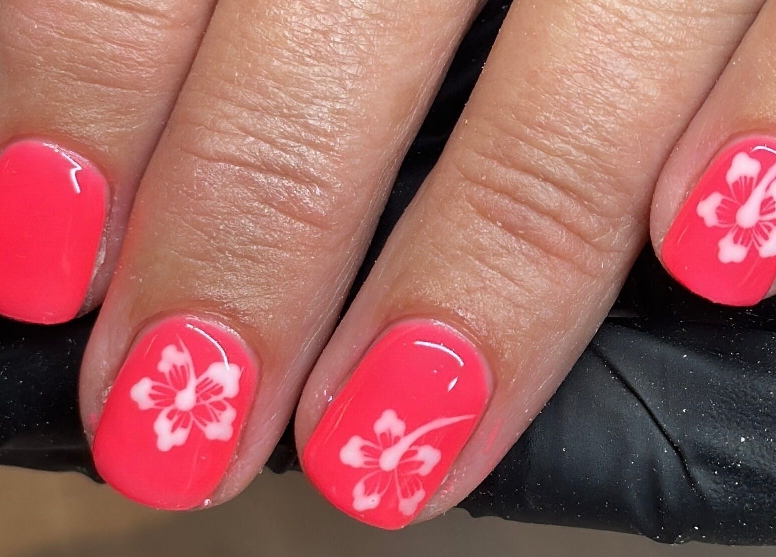 Vibrant pink nails with floral design at Byinke_X, West Kirby, England, GB; perfect for beauty enthusiasts.