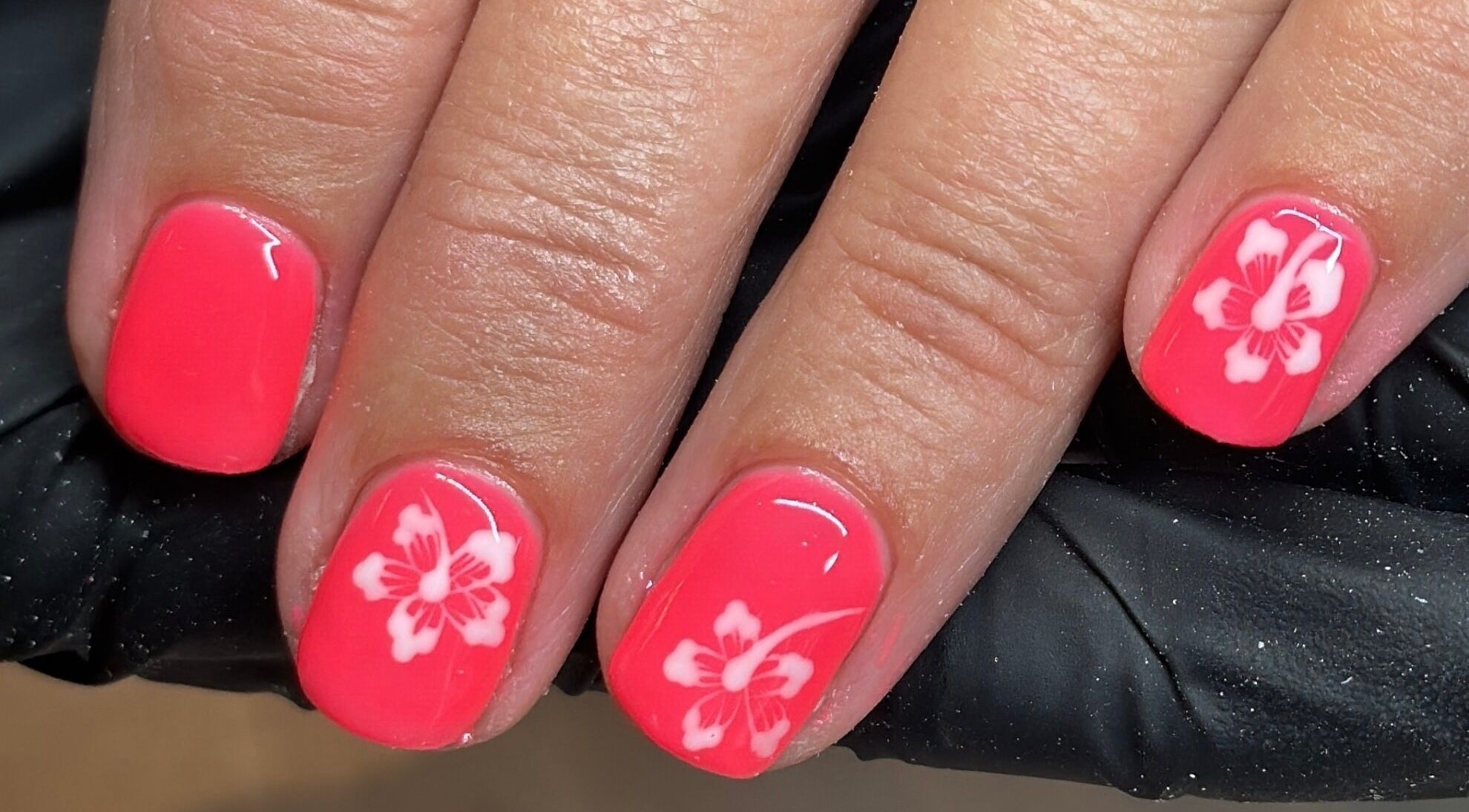 Vibrant pink nails with floral design at Byinke_X, West Kirby, England, GB; perfect for beauty enthusiasts.