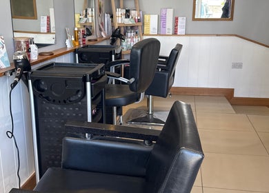 Modern styling station at Lavender Salon, Bradworthy, England, GB, featuring sleek black chairs and professional equipment.