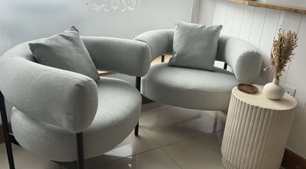 Elegant seating area in Lavender Salon, Bradworthy, England, GB with stylish chairs and side table.