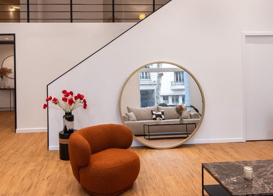 Intérieur chic de Le Petit Med Spa - Lyon, Auvergne-rhône-alpes, FR avec miroir rond et fauteuil orange.
