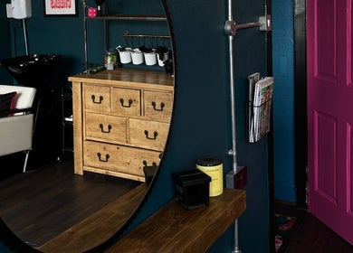 Elegant salon interior in Sacred Hair, North Shields, England, GB with a modern mirror and cozy styling chair.